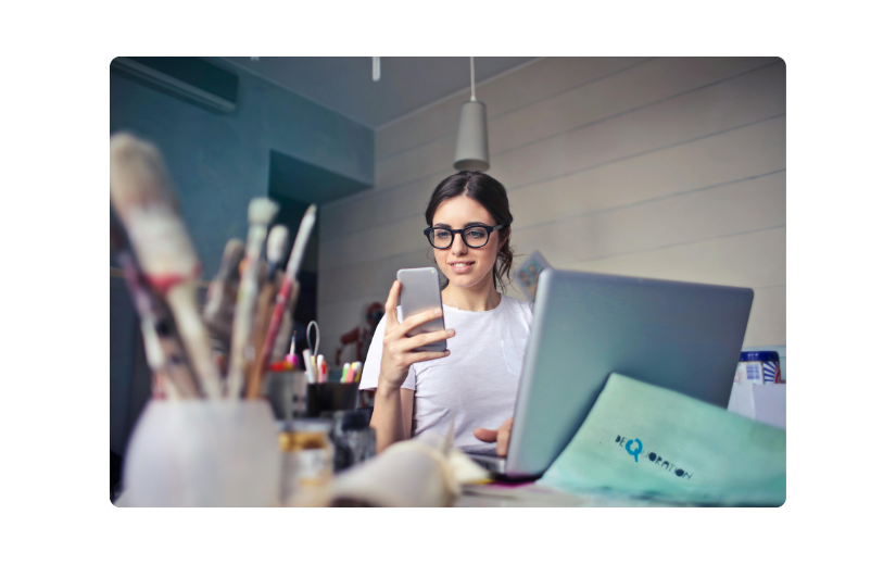 Woman using a smartphone and laptop, highlighting the growth of mobile eCommerce for online business and shopping.